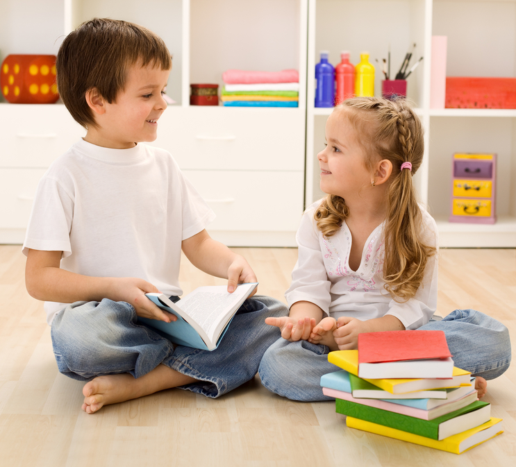 Let me tell you about school - siblings with books talking at home, back to school concept